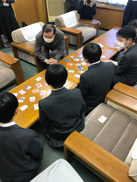 写真｜かるたの完成報告のため市役所訪問、市長とかるたを行う